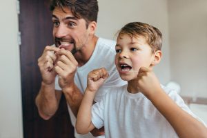 家族で歯ブラシ等で歯の予防ケアを行っている写真