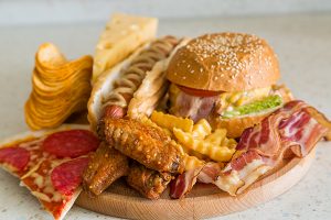 歯周病菌の増殖を促す食べ物としてピザやハンバーガー等の食べ物の写真