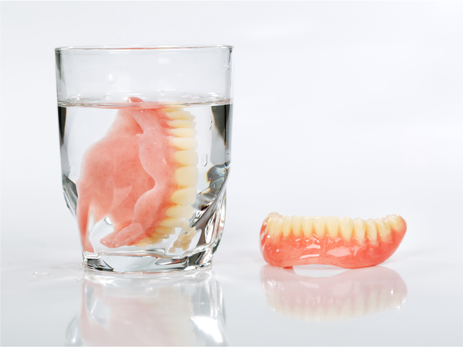 入れ歯洗浄剤が入ったグラスに入れ歯を浸している画像