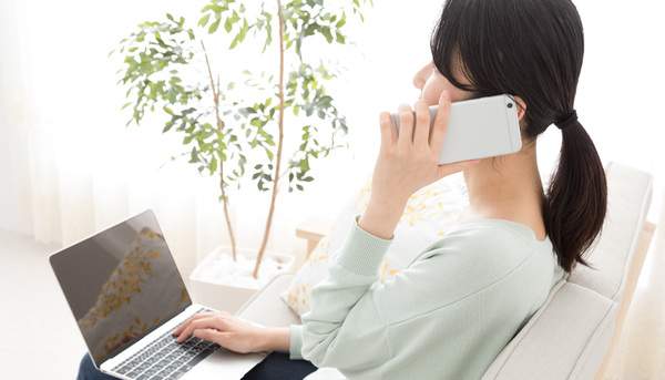 麻布十番歯科の予約状況を確認し電話で予約を取る女性の写真